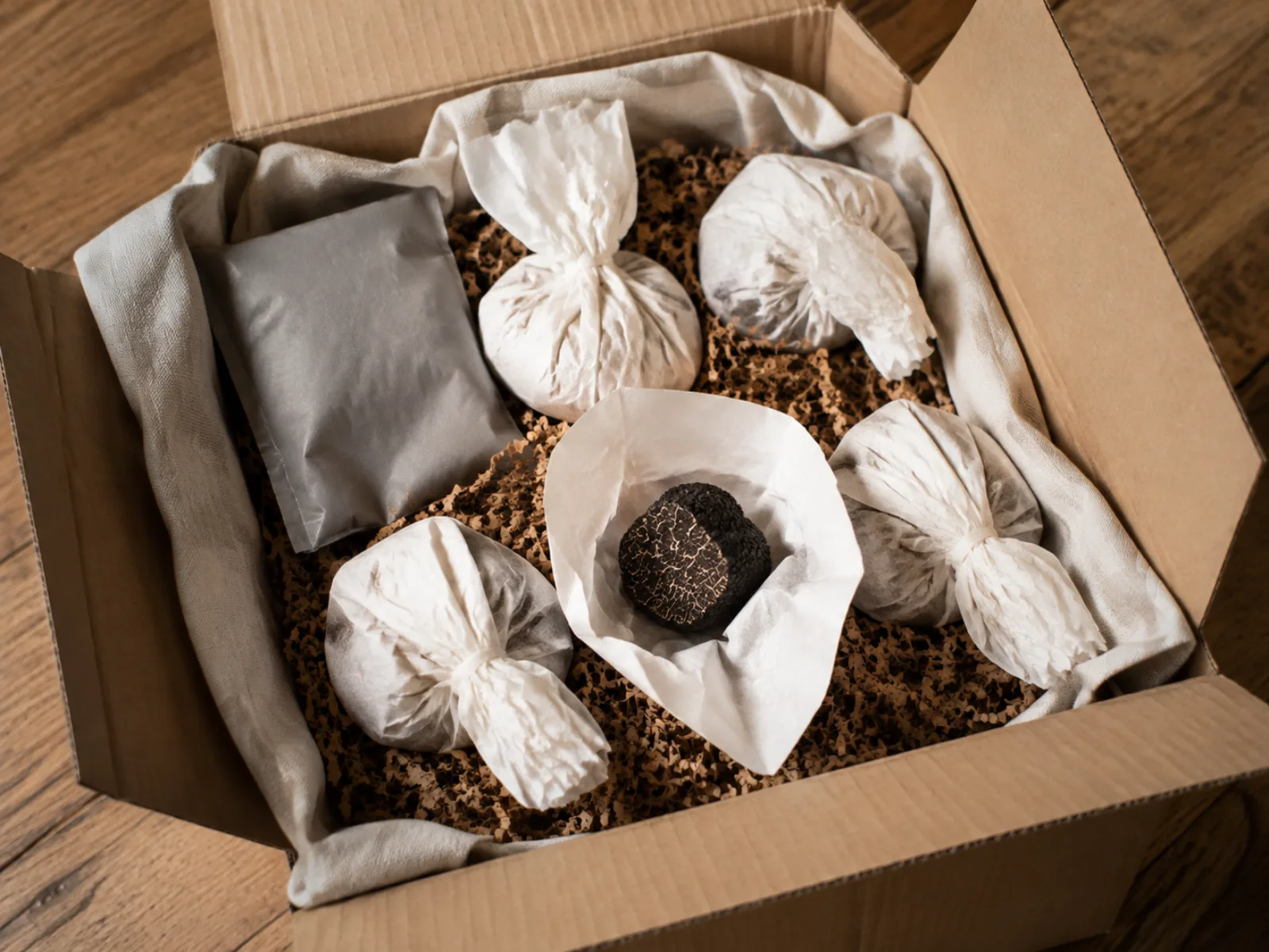Geöffnete Isolierbox mit einzeln eingeschlagenen Trüffeln und Kühlakku